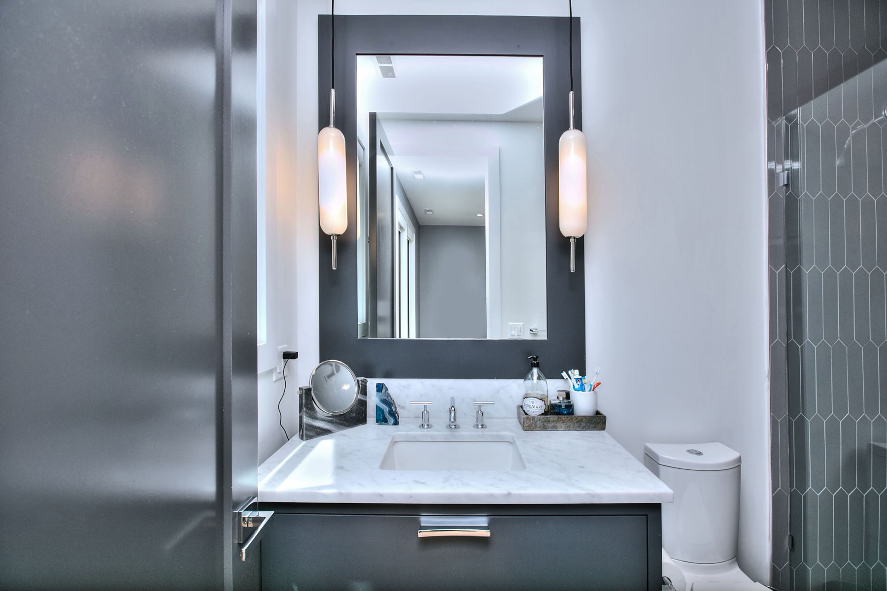 Vanity with sconces and a dark frame mirror