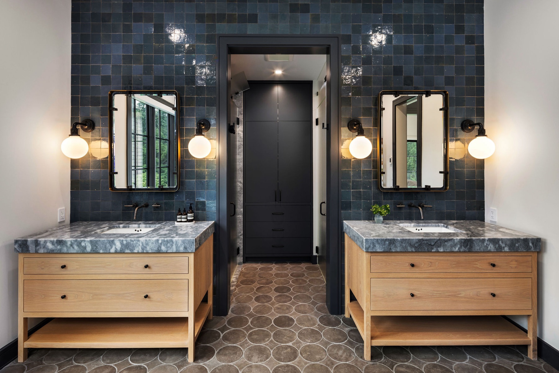 Master bath with dark tile and twin oak vanities