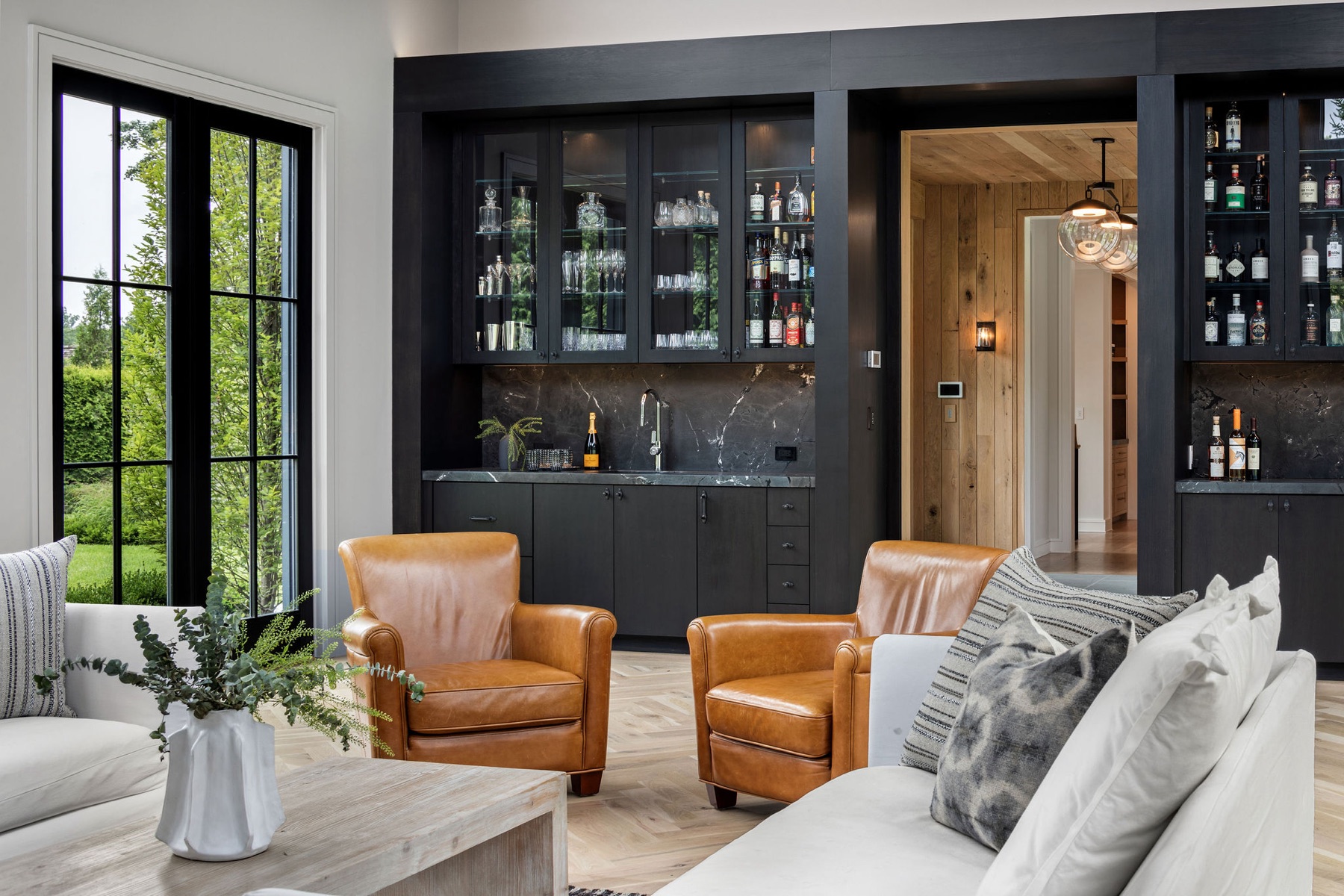 Bar and lounge with navy cabinetry and leather chairs
