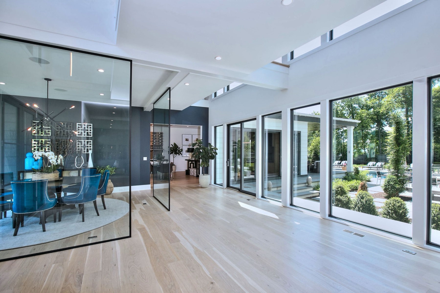 Glass-walled dining room off an open hallway