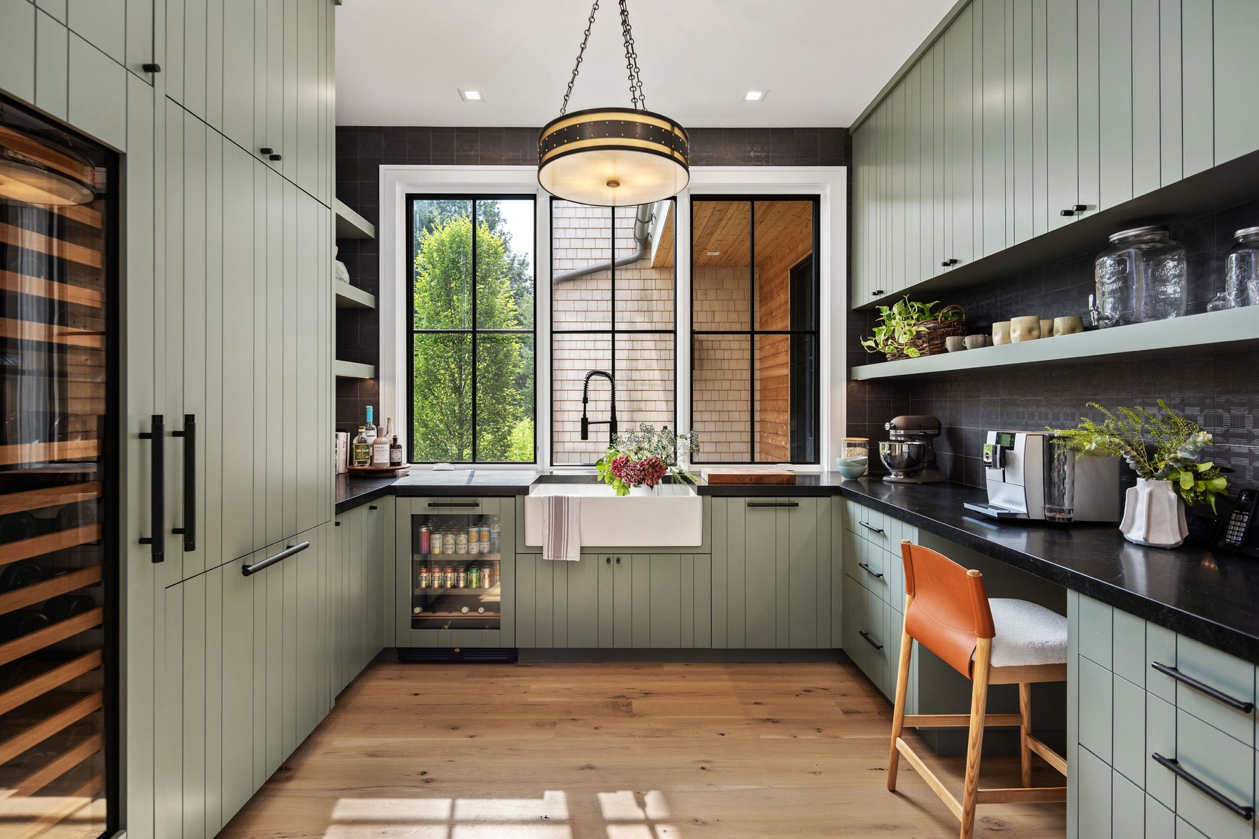 Scullery with sage cabinetry and black counters