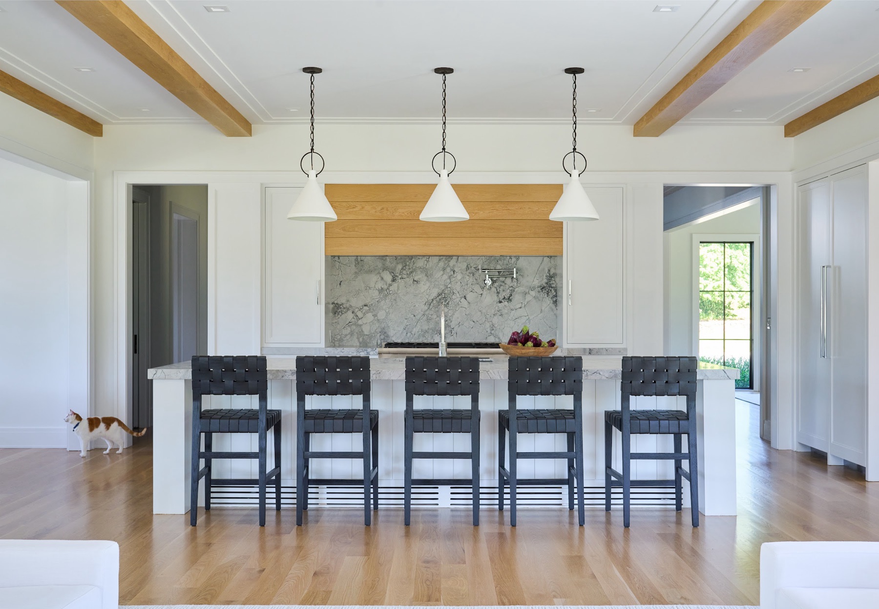 Kitchen with a marble range hood and dark island
