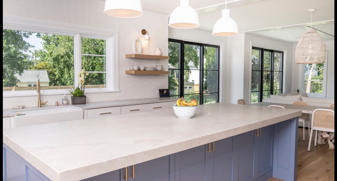 Island with blue cabinetry and pendants